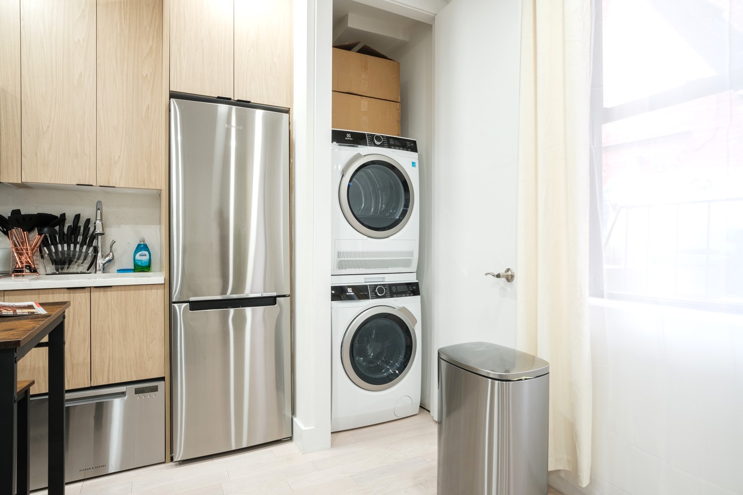 Stacked washer and dryer beside the fridge